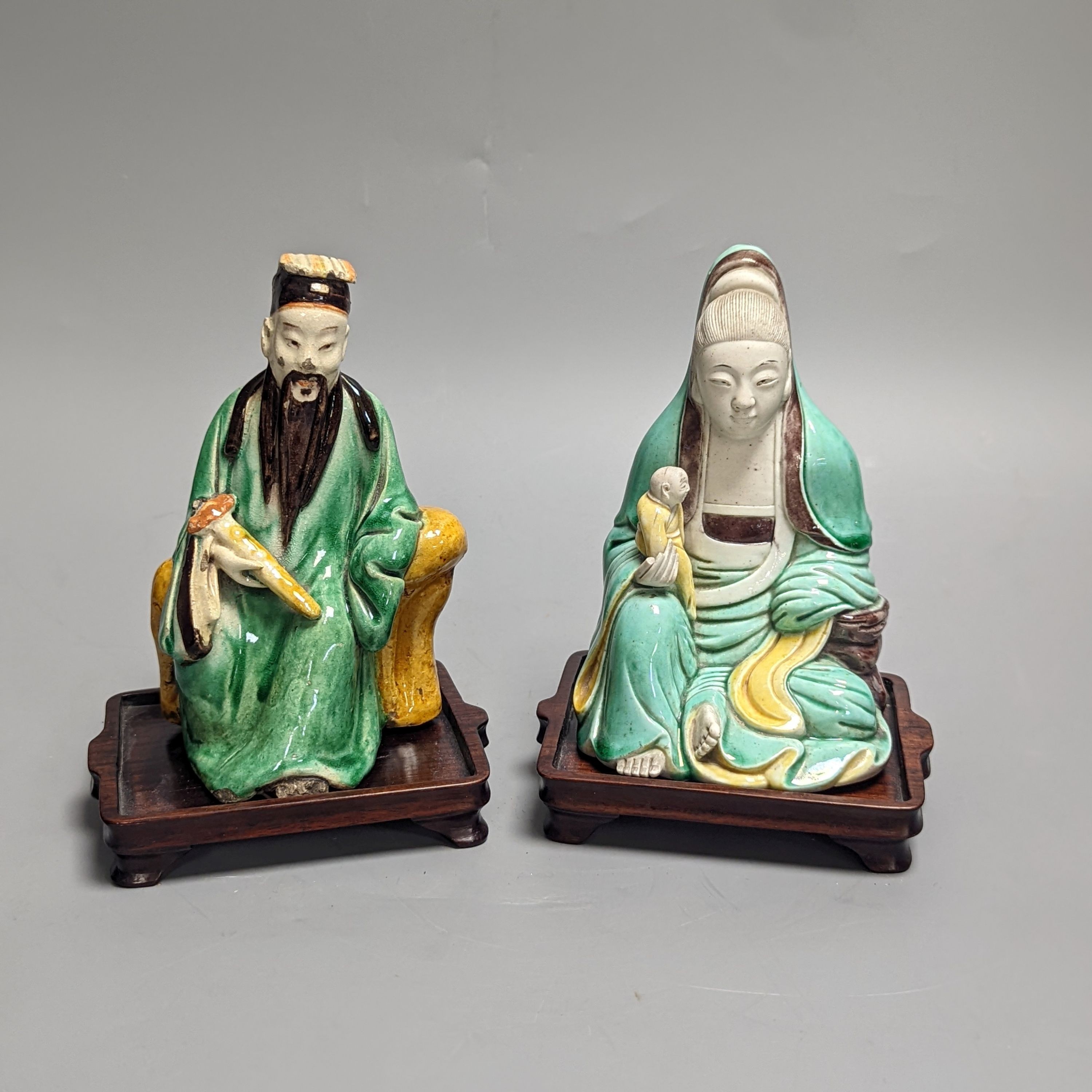 An 18th century Chinese sancai biscuit group of Guanyin with child and a 19th century Chinese sancai figure of Lu Dongbin, associated hardwood stands. 16cm